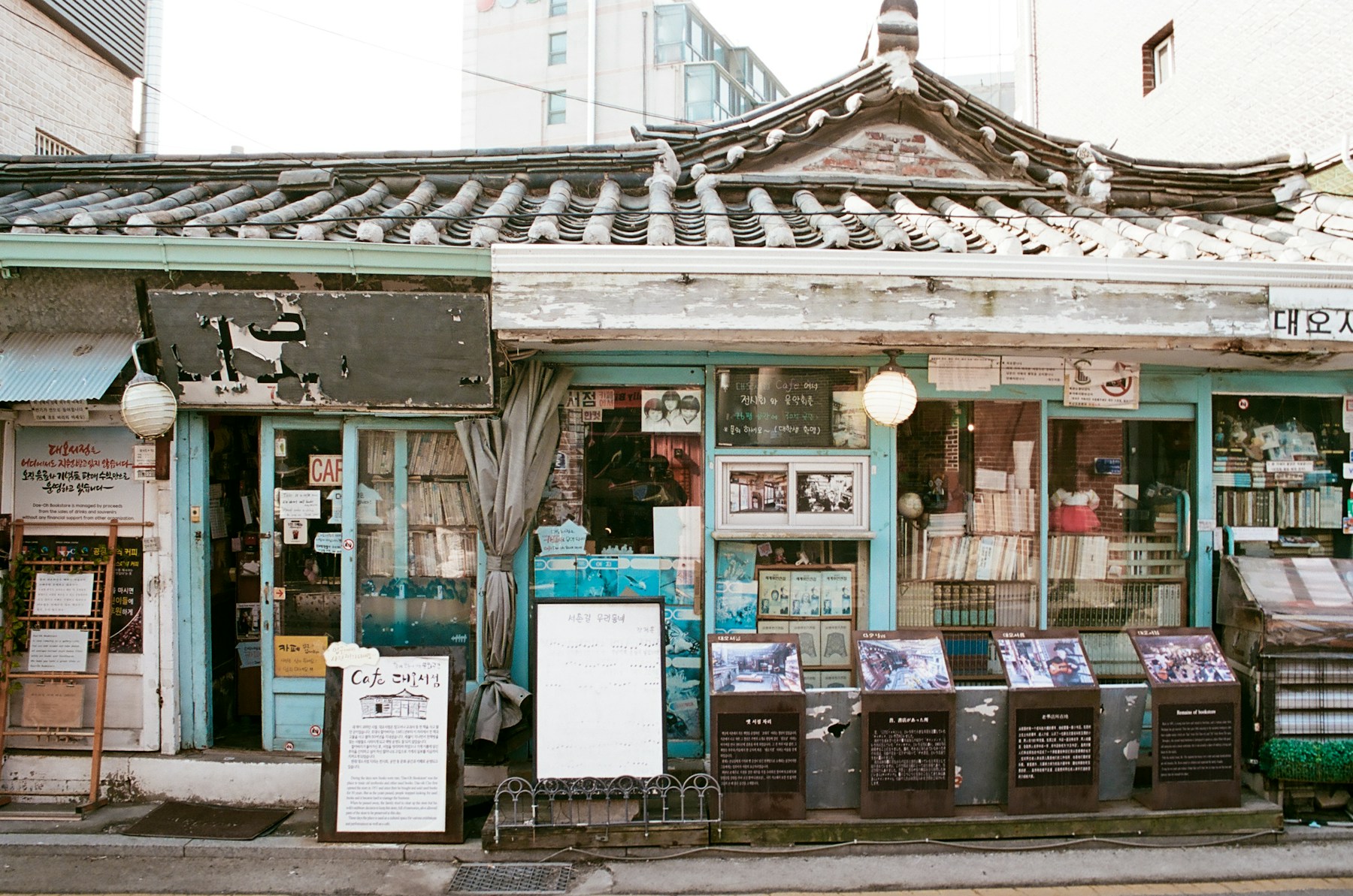 The turquoise storefront and tiled roof of Daeo Bookstore in Seochon