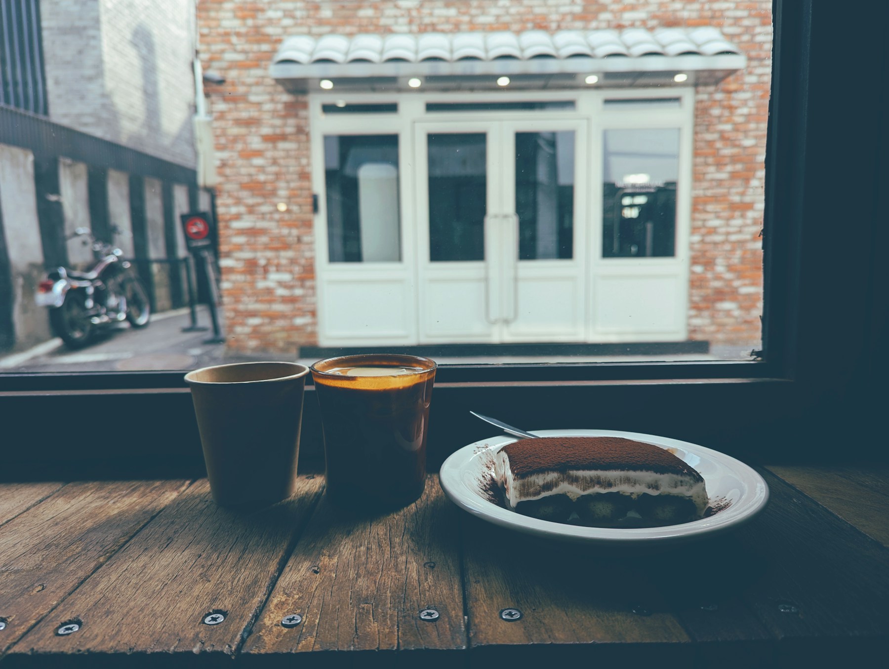 Coffee and tiramisu on a wooden counter at a Seoul cafe