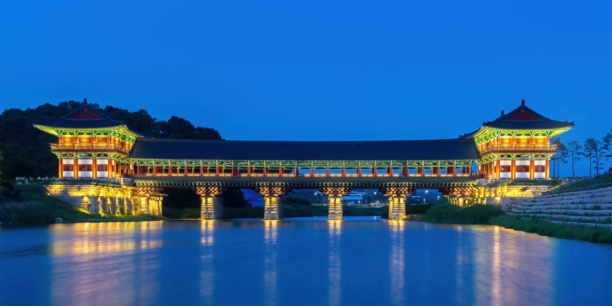 Illuminated Woljeonggyo Bridge reflected in the river at blue hour.