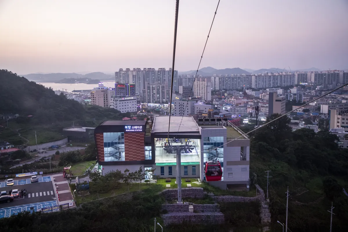 Cable cars above Mokpo city at dusk.